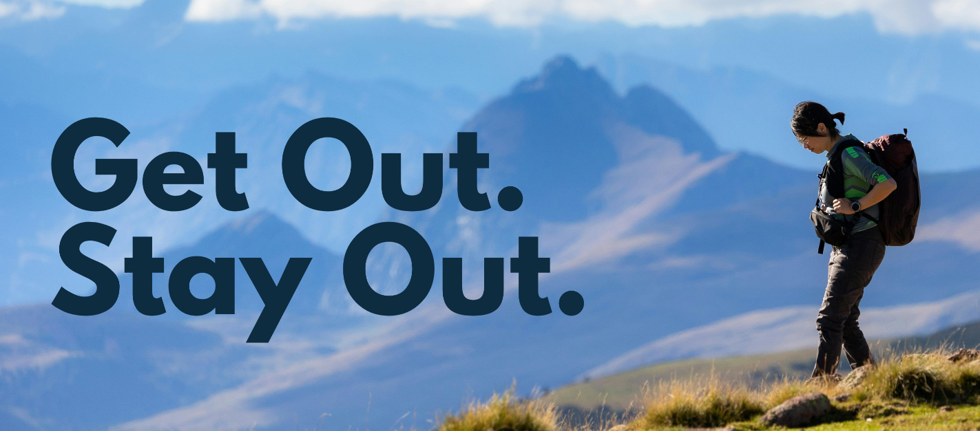 Person with a backpack standing on a mountain with the text 'Get Out. Stay Out.'