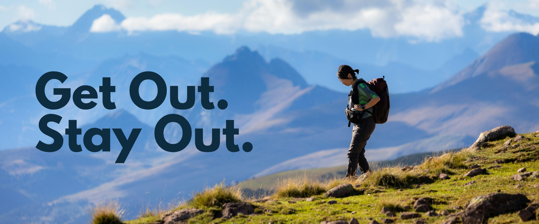 Person with a backpack standing on a mountain with the text 'Get Out. Stay Out.'